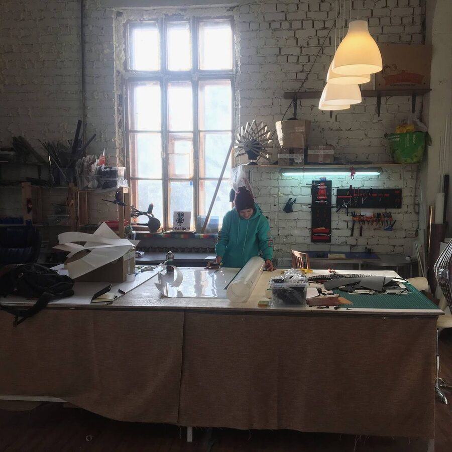 Peasok Studio cutting table with a roll of clear film, pegboard tool walls