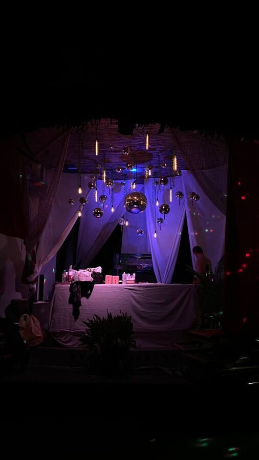 The same canopy under purple light, drapes and mirror balls
