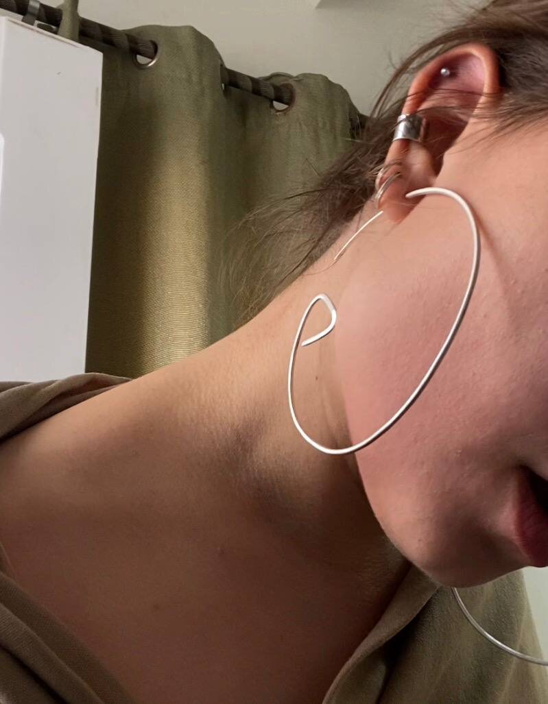 Oversized silver spiral hoop earring and ear cuff, worn